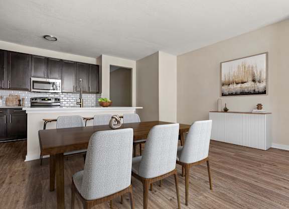 A dining room with a wooden table and chairs.