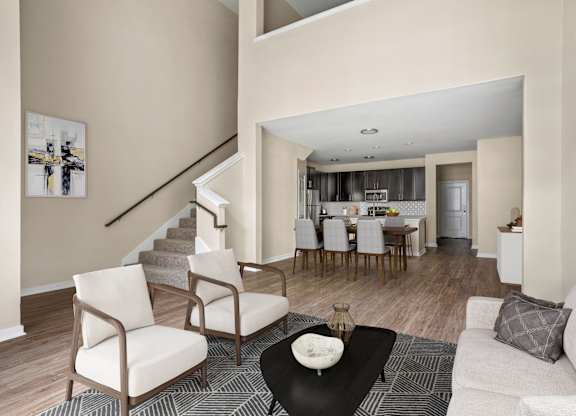 A living room with a staircase and a dining area.