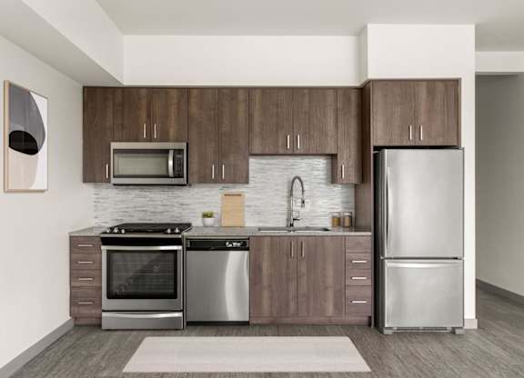 A modern kitchen with a refrigerator, oven, and microwave.