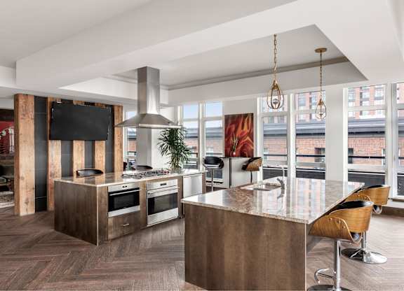A modern kitchen with a wooden island and bar stools.