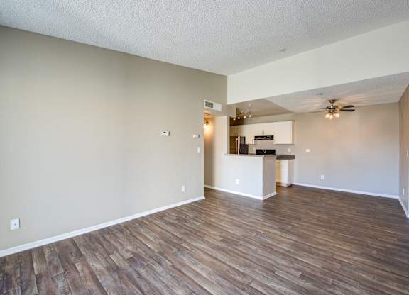 A room with wooden flooring and a ceiling fan.