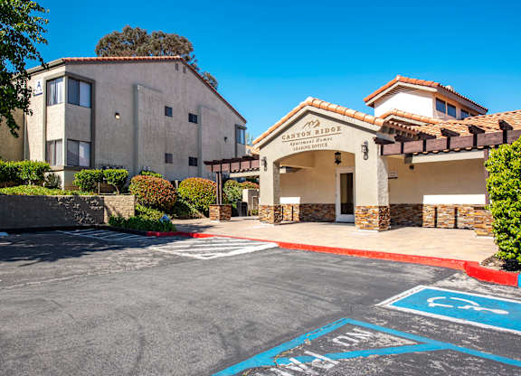 A parking lot with a building named Canyon Sides in the background.