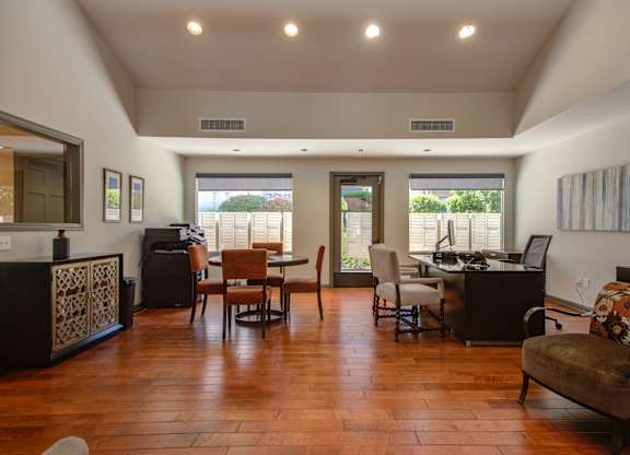 A living room with a brown wooden floor and furniture.