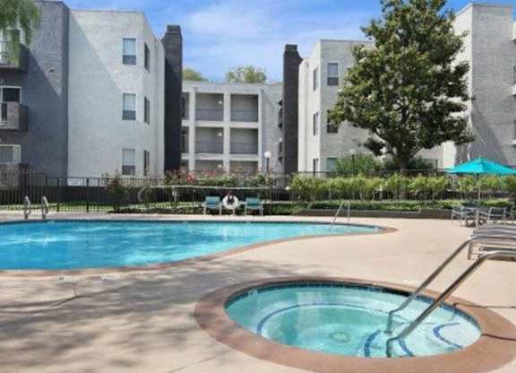 A swimming pool in front of apartment buildings.