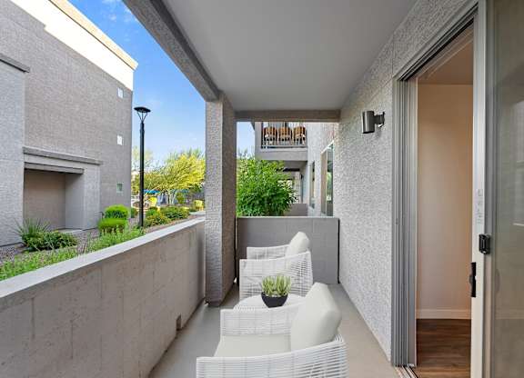 A patio with white chairs and a table.