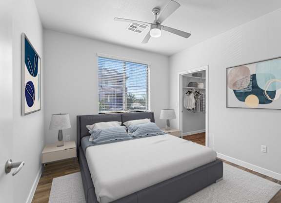 A bedroom with a bed, a ceiling fan, and two wall art pieces.