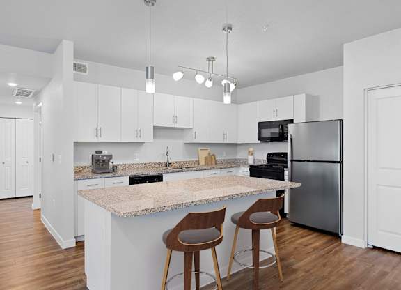 A kitchen with a granite countertop and a refrigerator.