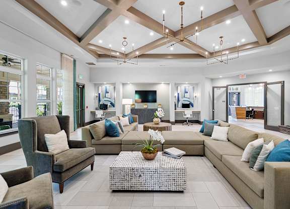 A spacious living room with a variety of seating options and a coffee table in the center.