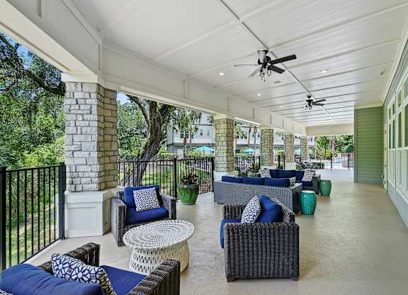 A patio with a black railing and furniture.