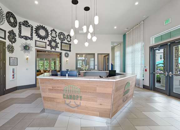 A reception area with a wooden desk and a sign that says "CANOPY".