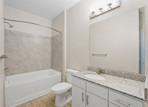 A white bathroom with a toilet, sink, and bathtub.
