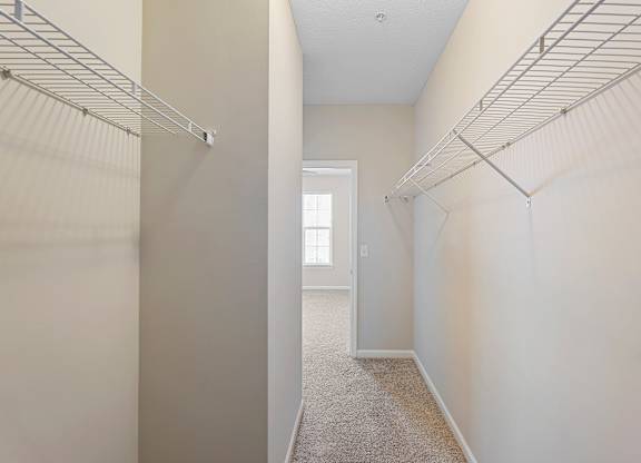 A long hallway with a carpeted floor and white walls.