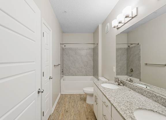 A white bathroom with a toilet, sink, and shower.