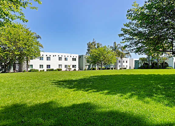 A white building with a green lawn in front of it.