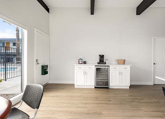 A kitchen with white cabinets and a wooden floor.