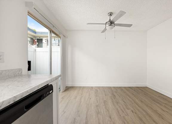 A room with a ceiling fan and a marble countertop.