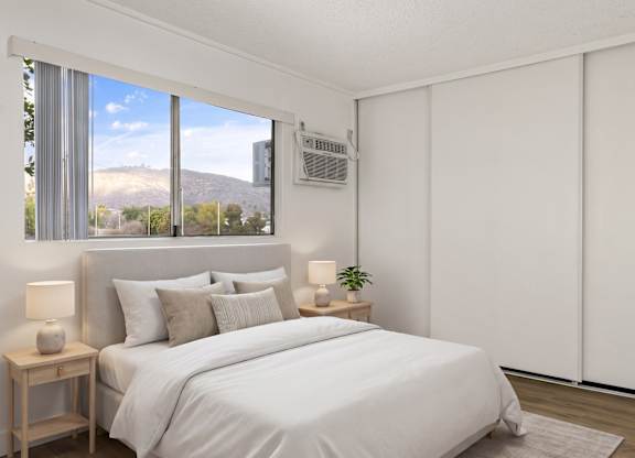 A bedroom with a large bed and a window overlooking a mountain.
