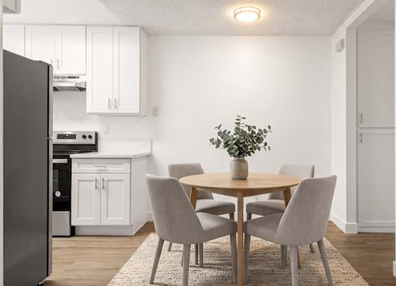 A kitchen with a table and chairs.