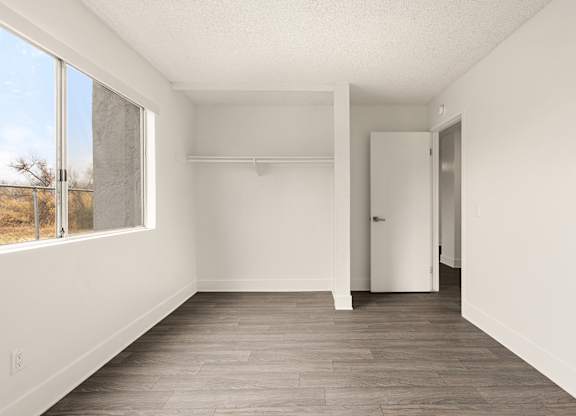 Empty room with white walls and wood flooring.