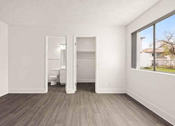 A room with a toilet and a bed in it.