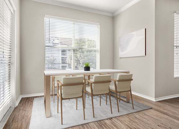 A dining room with a table and chairs.