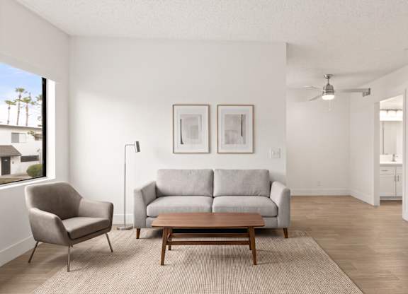 A living room with a grey couch, a chair, and a table.