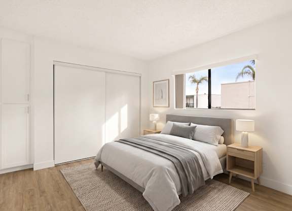 A bedroom with a bed, nightstand, and a window.
