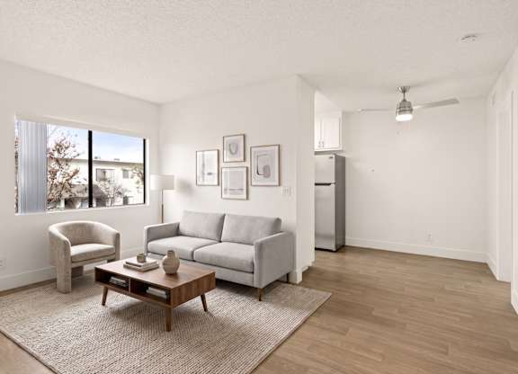 A living room with a grey couch, a brown coffee table, and a white chair.