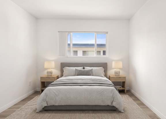 A bedroom with a large bed and two lamps.