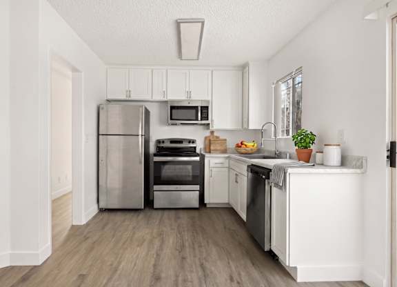 A kitchen with white cabinets and stainless steel appliances.