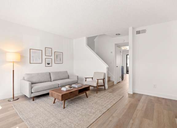A living room with a grey couch and a wooden coffee table.