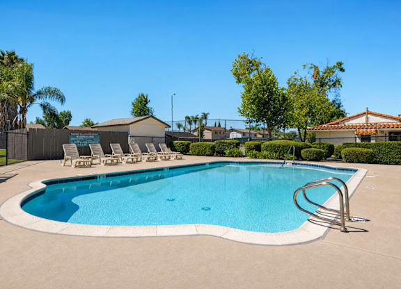 A large outdoor swimming pool with a metal ladder.