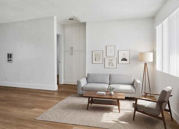 A living room with a grey couch, a wooden coffee table, and a lamp.
