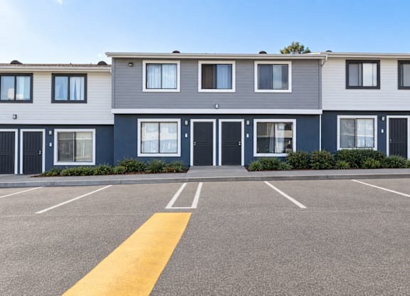 A parking lot in front of a row of townhouses.