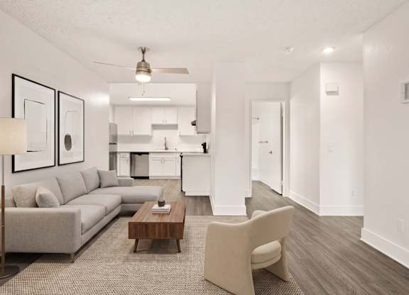 A modern living room with a grey sofa, a wooden coffee table, and a beige armchair.