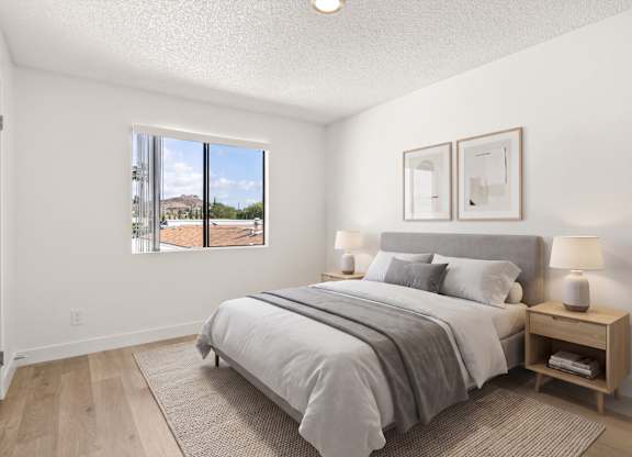 A bedroom with a large bed and a window overlooking a street.