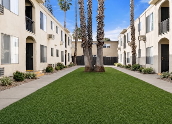 A row of houses with a green lawn in the middle.