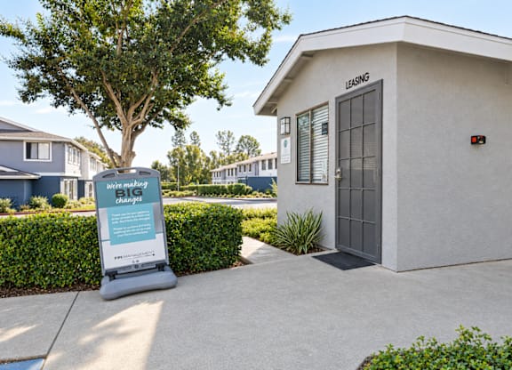 A small building with a sign in front of it that says "BIG".