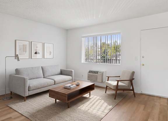A living room with a grey couch, a brown coffee table, and a chair.