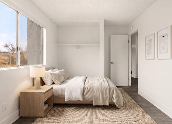 A bedroom with a bed, nightstand, and two pictures on the wall.