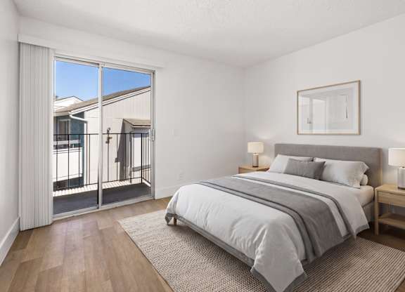 A bedroom with a large bed and a view of the outside.