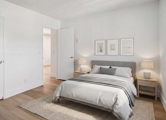 A bedroom with a large bed and two nightstands.