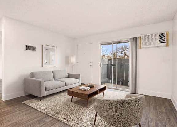 A living room with a grey couch, a wooden coffee table, and a chair.