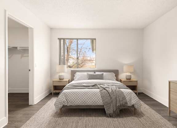 A bedroom with a bed, nightstands, and a window.