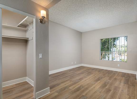 Empty room with wood flooring and a window.