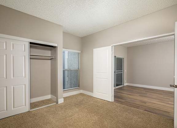A room with a white door and a window with blinds.
