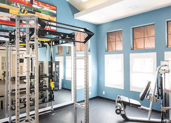 A gym with a blue wall and a variety of equipment.