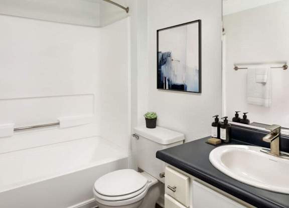 A white toilet sits next to a sink in a bathroom.