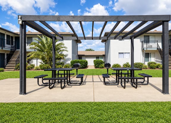 A patio with a table and chairs under a pergola.
