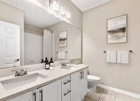 A bathroom with a white toilet, a sink, and a mirror.
